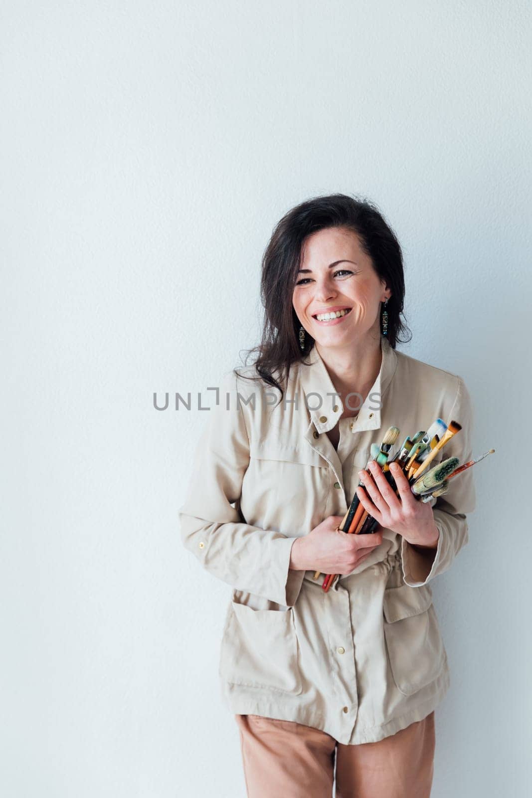 Photo of smiling good mood woman construction worker laughing hold paint brush isolated on yellow color background