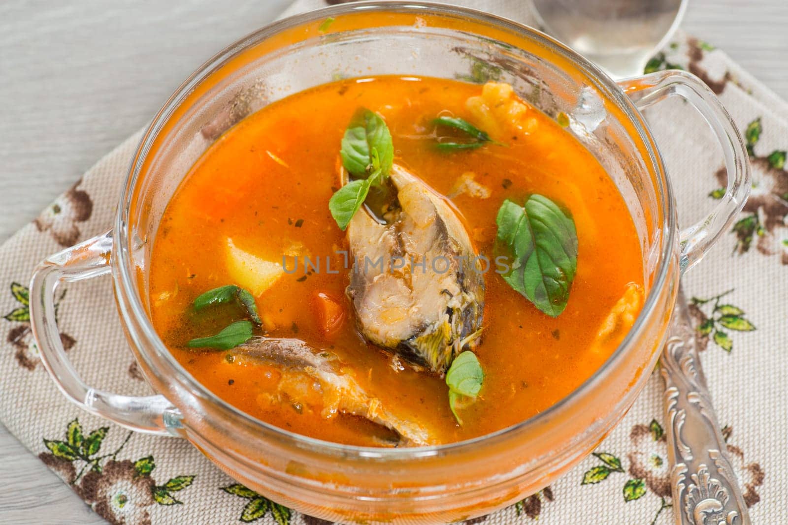 vegetable tomato soup with fish in a plate on a wooden table