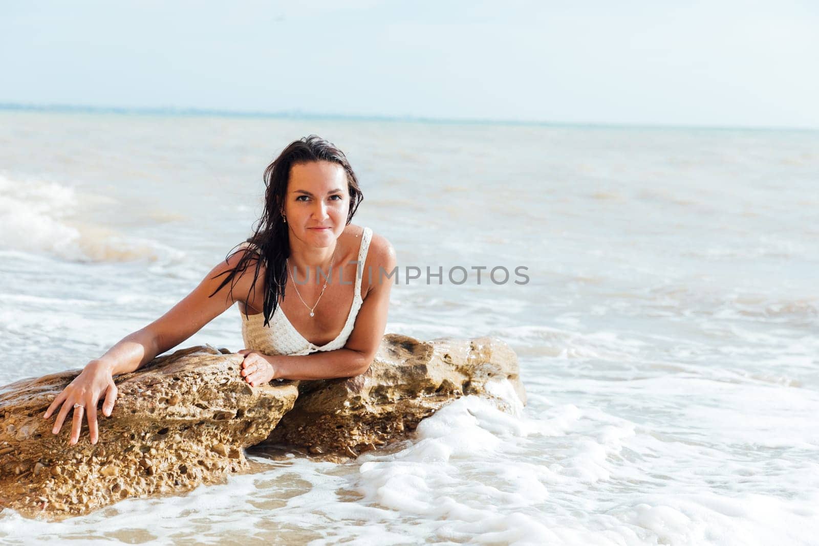tanned woman bathing on the beach in the sea