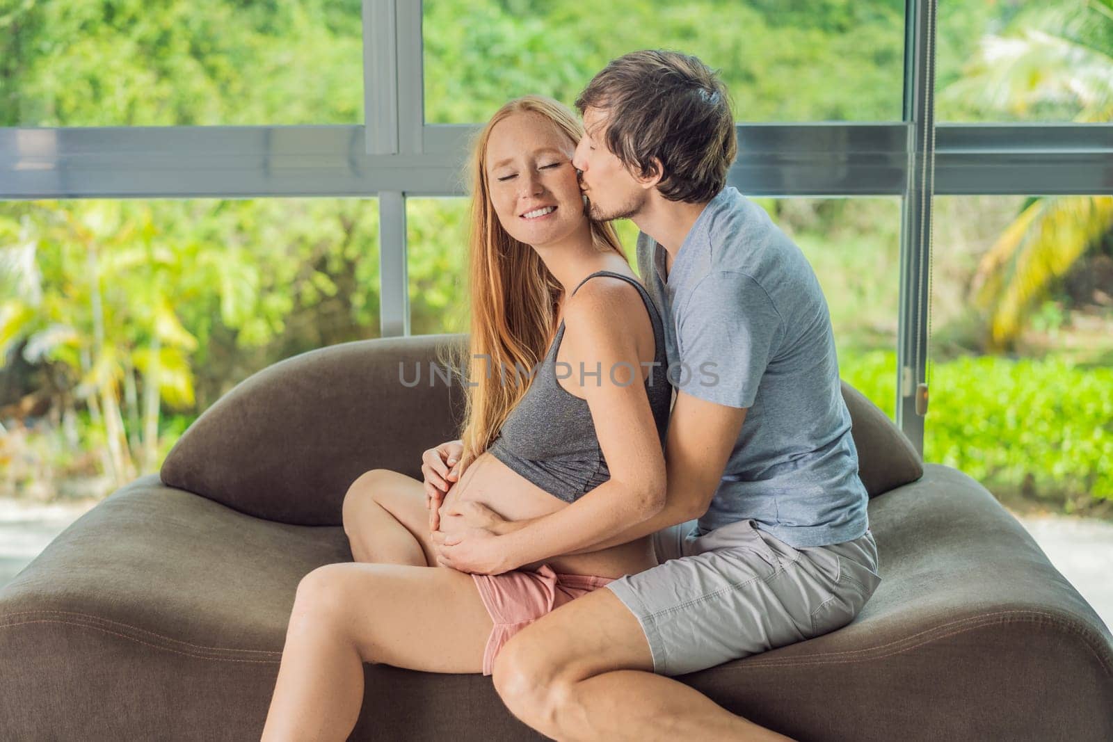 health, pregnancy and happy people concept - husband giving his wife back massage at home by galitskaya