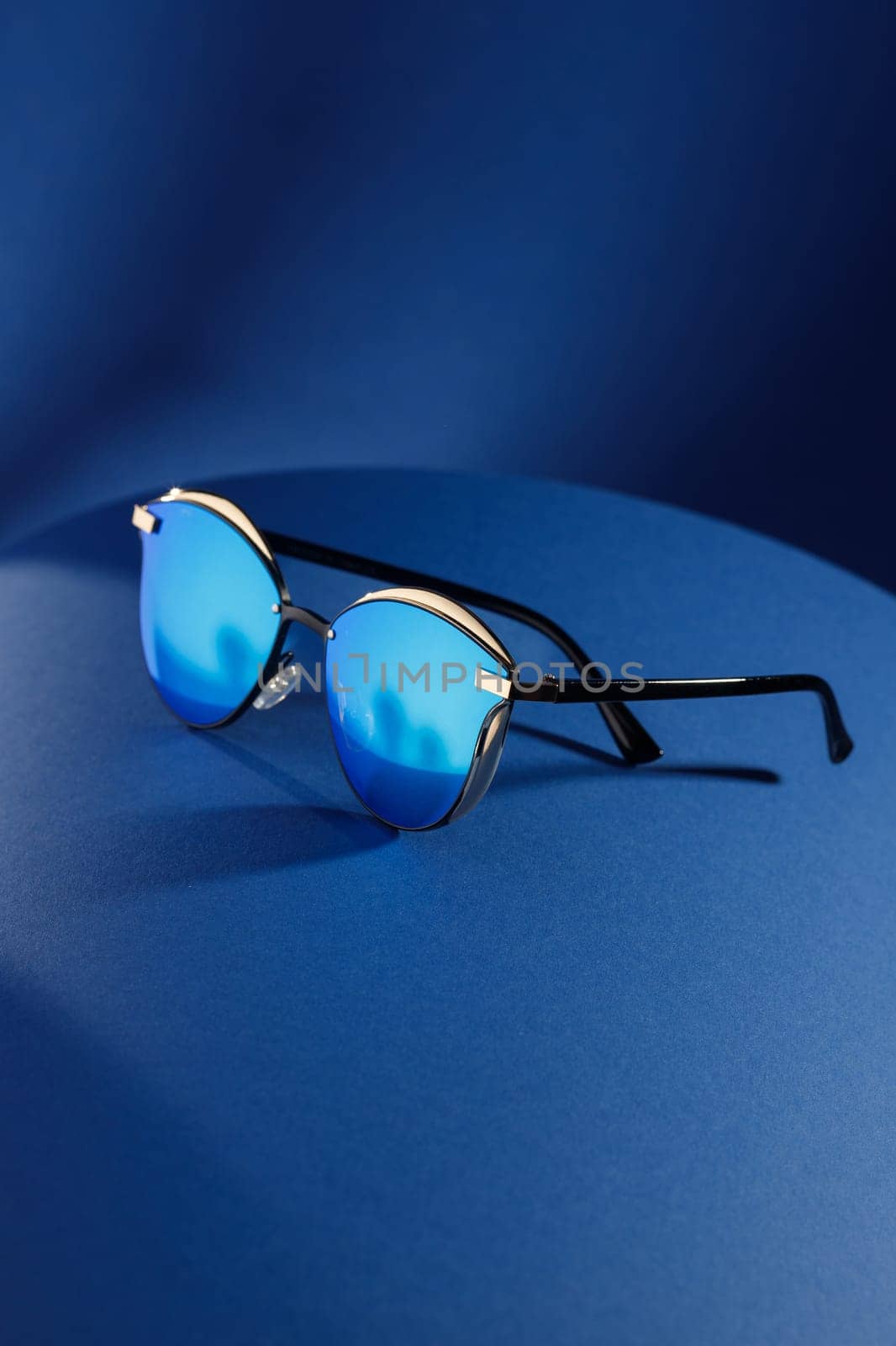 Trendy sunglasses background. Fashion summer accessories. Copy space for text. Blue concept. Optic store discount poster by Gravika