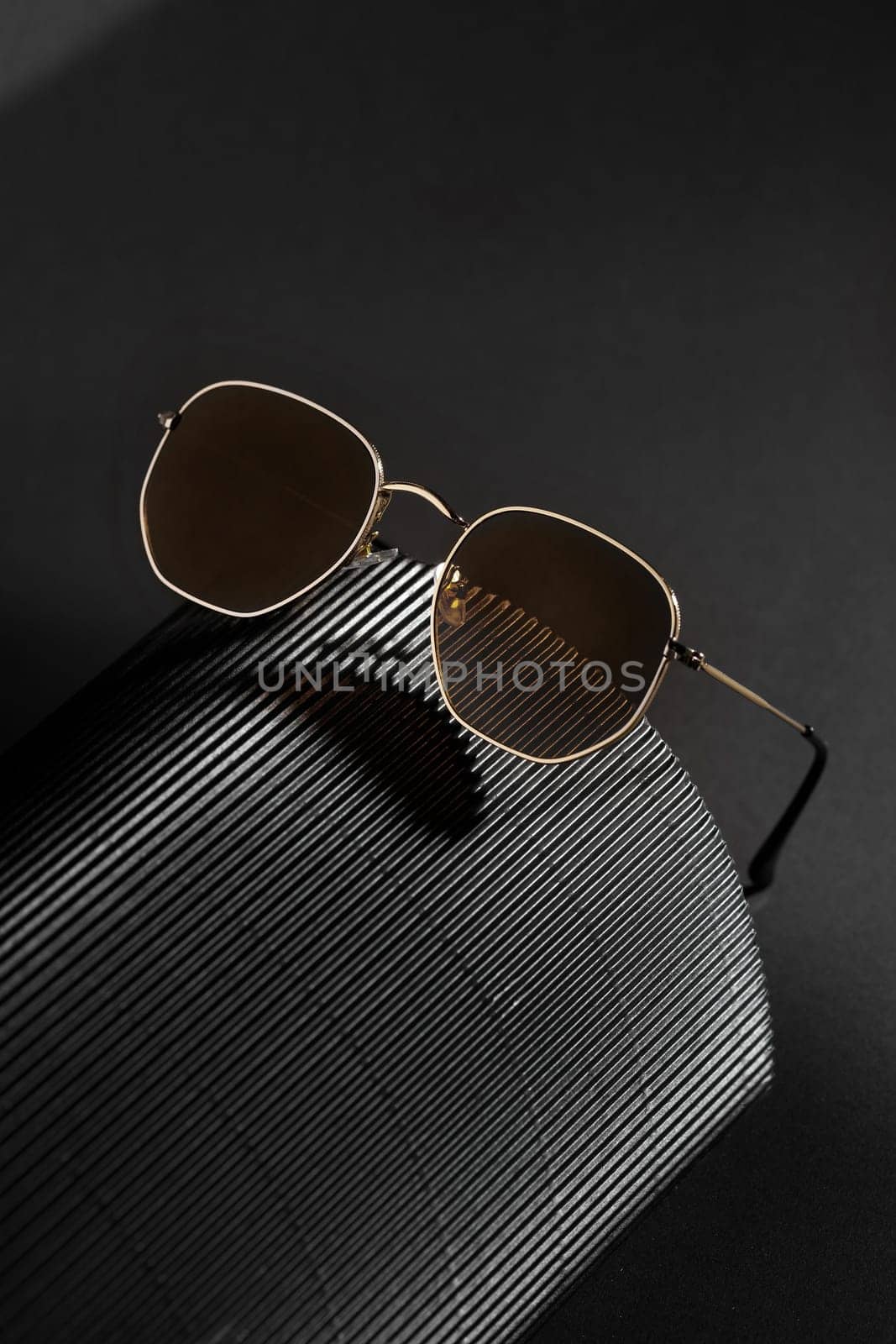 Trendy sunglasses background. Fashion summer accessories. Copy space for text. Black gold concept. Optic store discount poster by Gravika