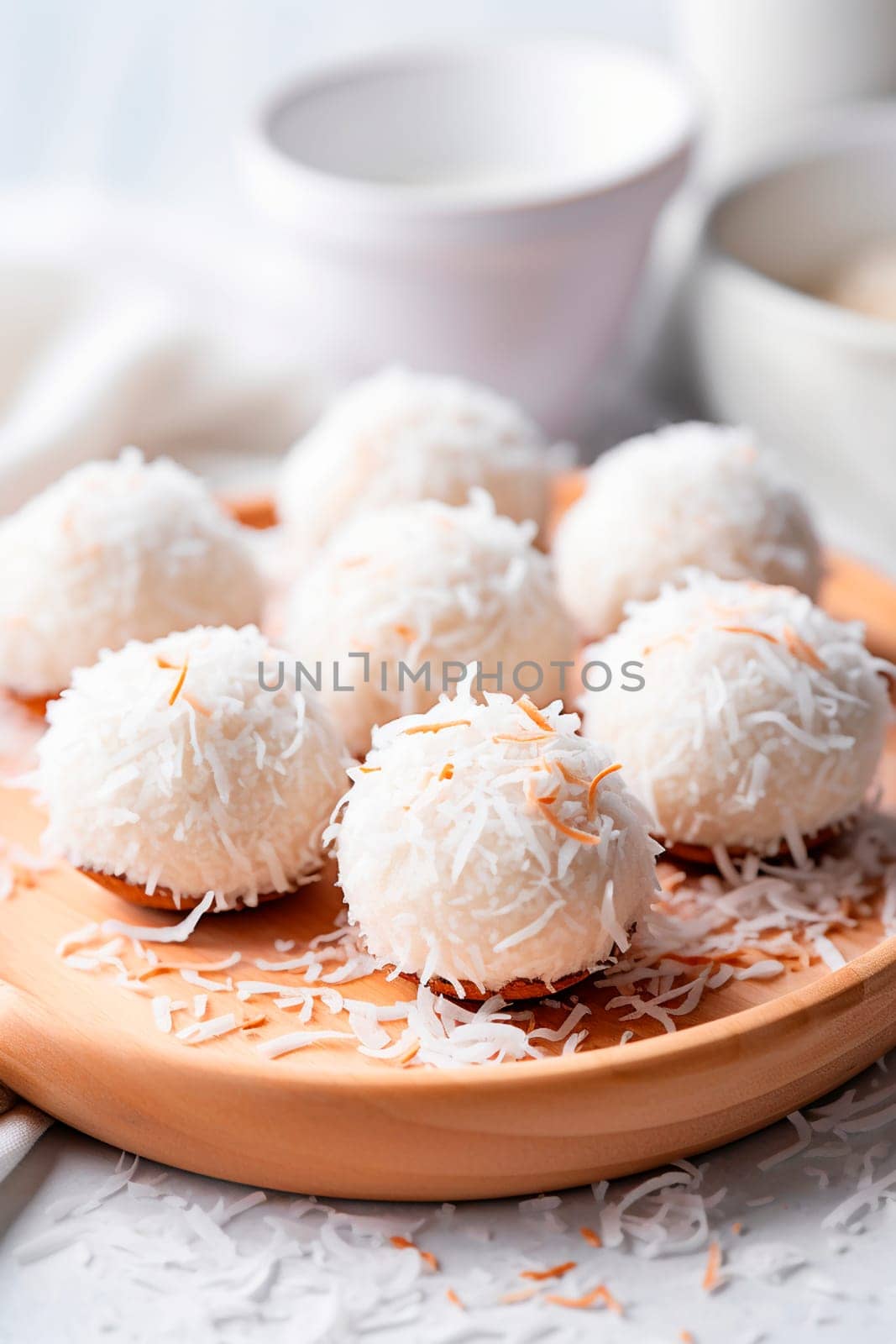 Coconut balls dessert with coconut flakes. Generative AI, by yanadjana