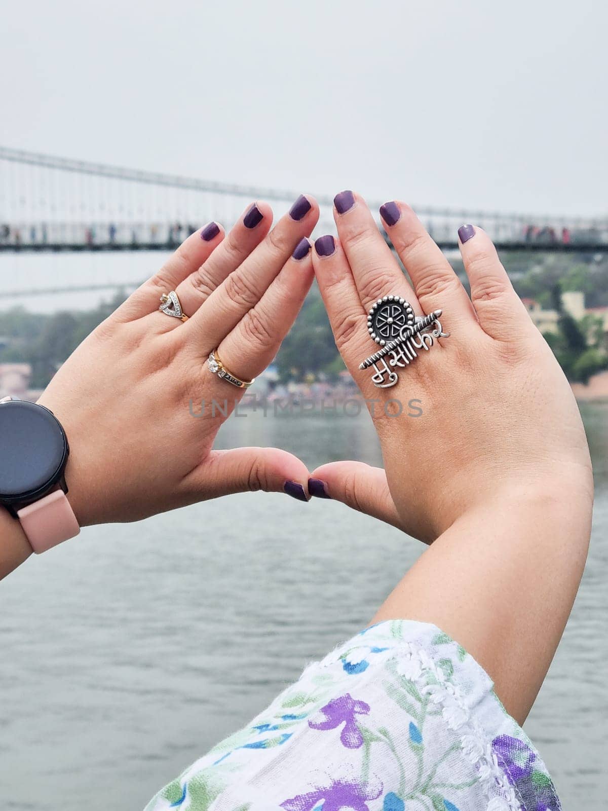 Hands of indian woman with purple nail polish and ring saying musafir meaning traveller in Hindi showing the trend of travelling across India