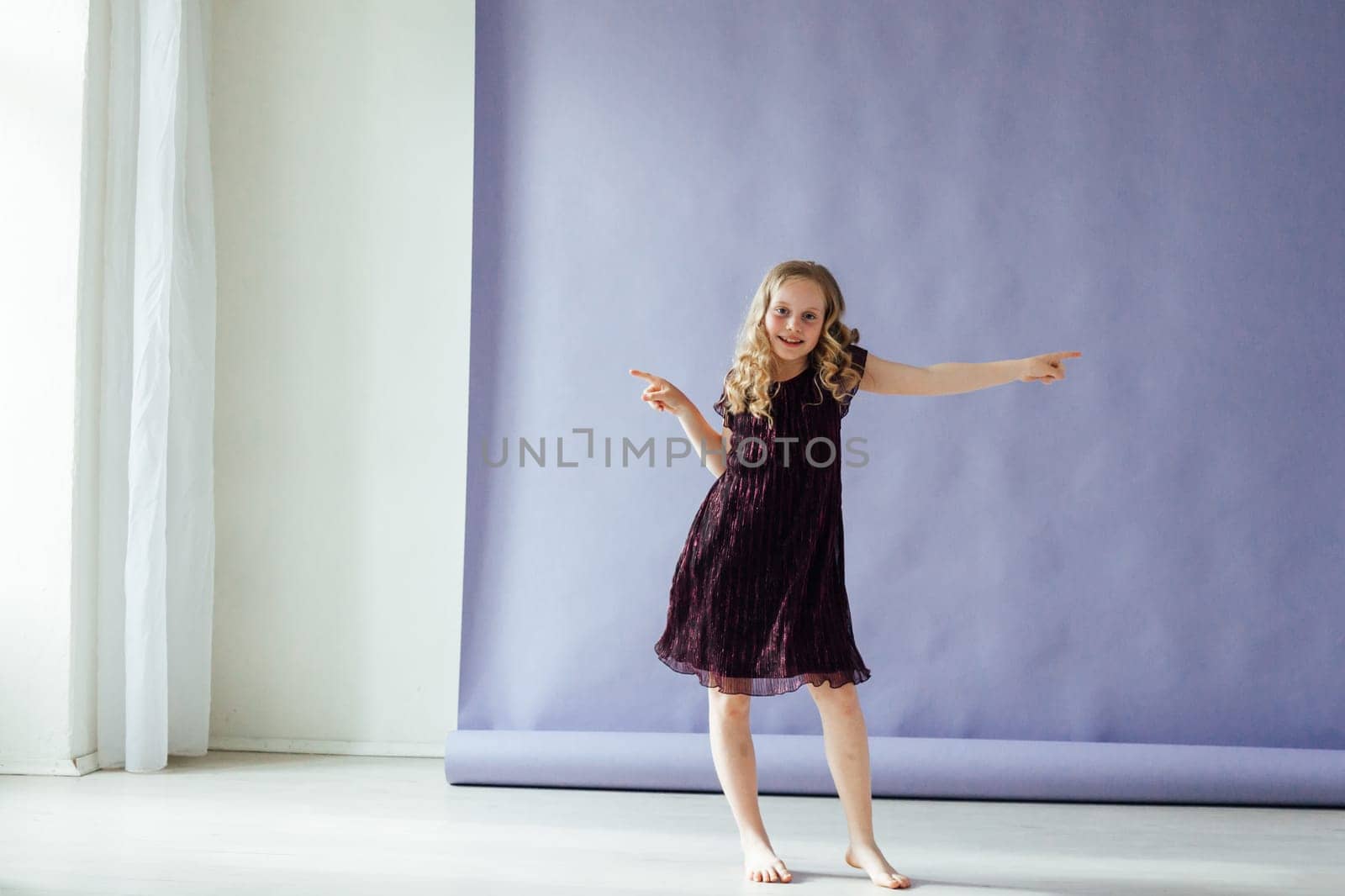 Girl in a dress dances to the music alone in the room by Simakov