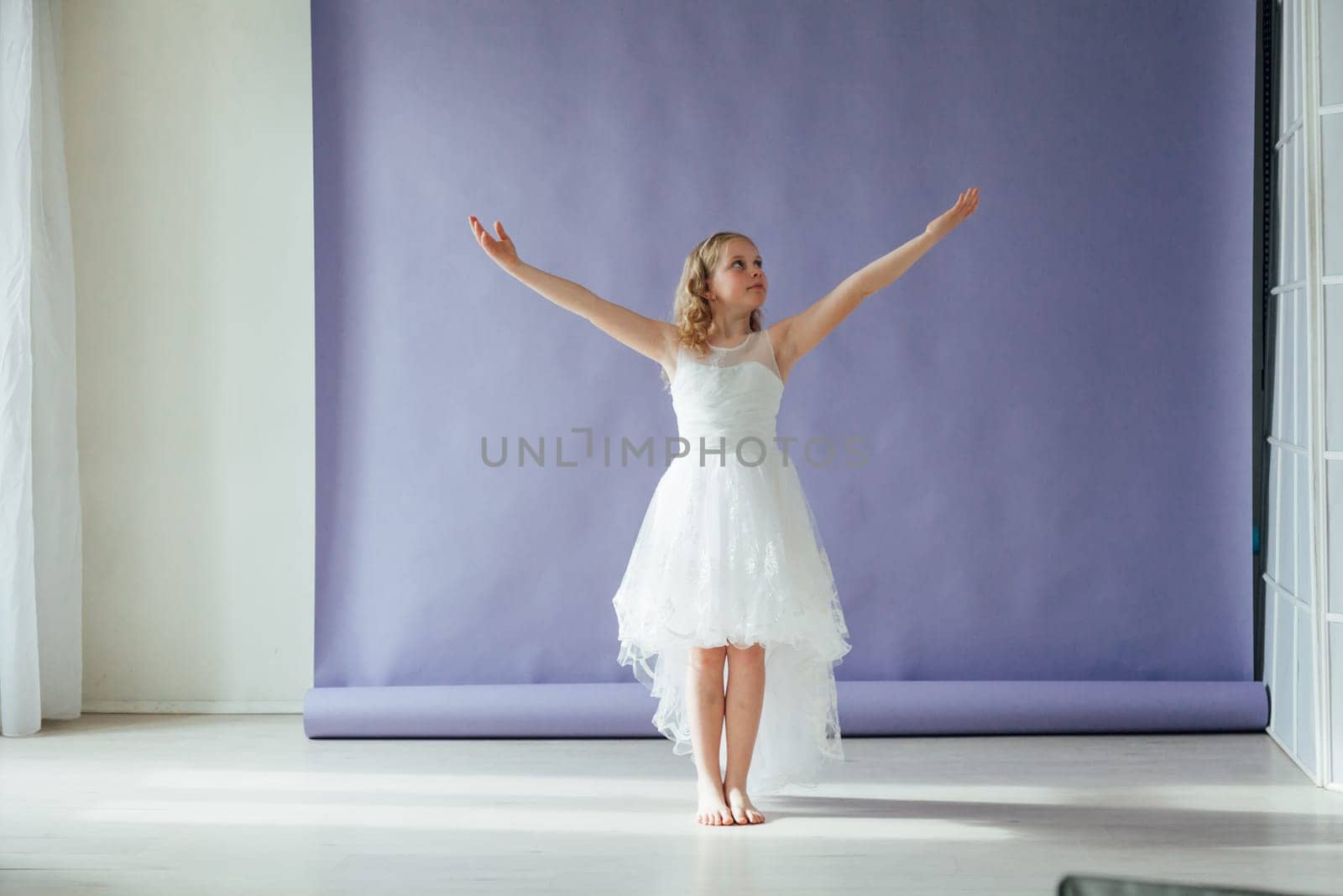 Girl in a dress dances to the music alone in the room by Simakov