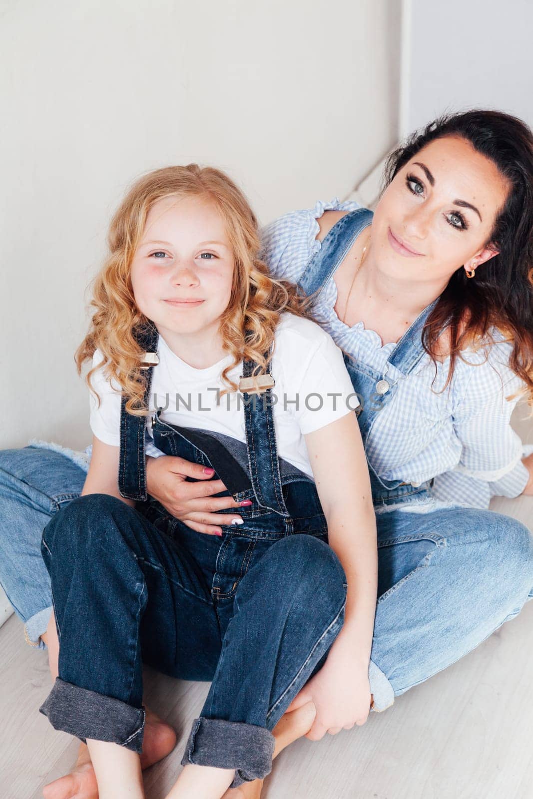 portrait of mother and daughter in denim clothes in a room