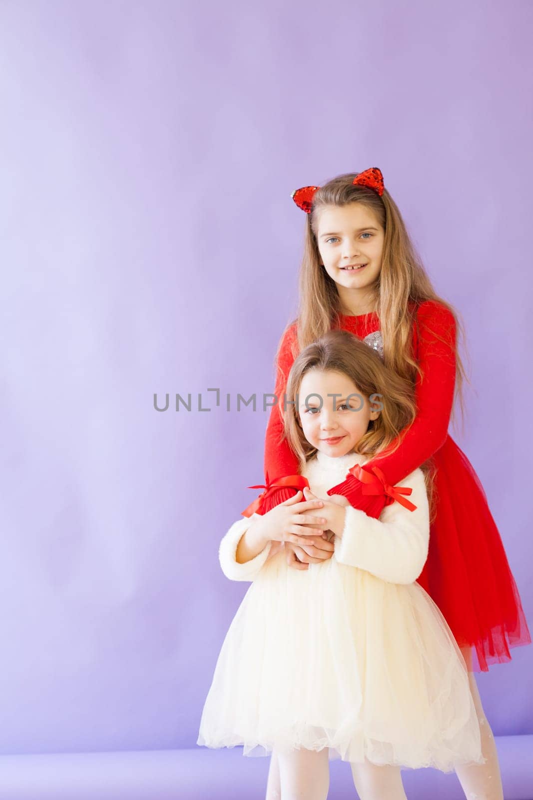 two girl in red and white dresses on a purple background