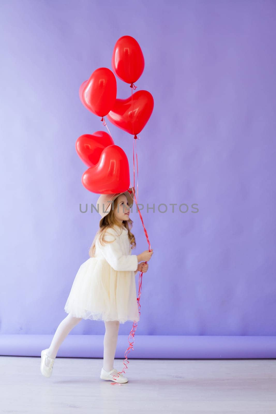 Little girl with red air in the shape of a heart by Simakov