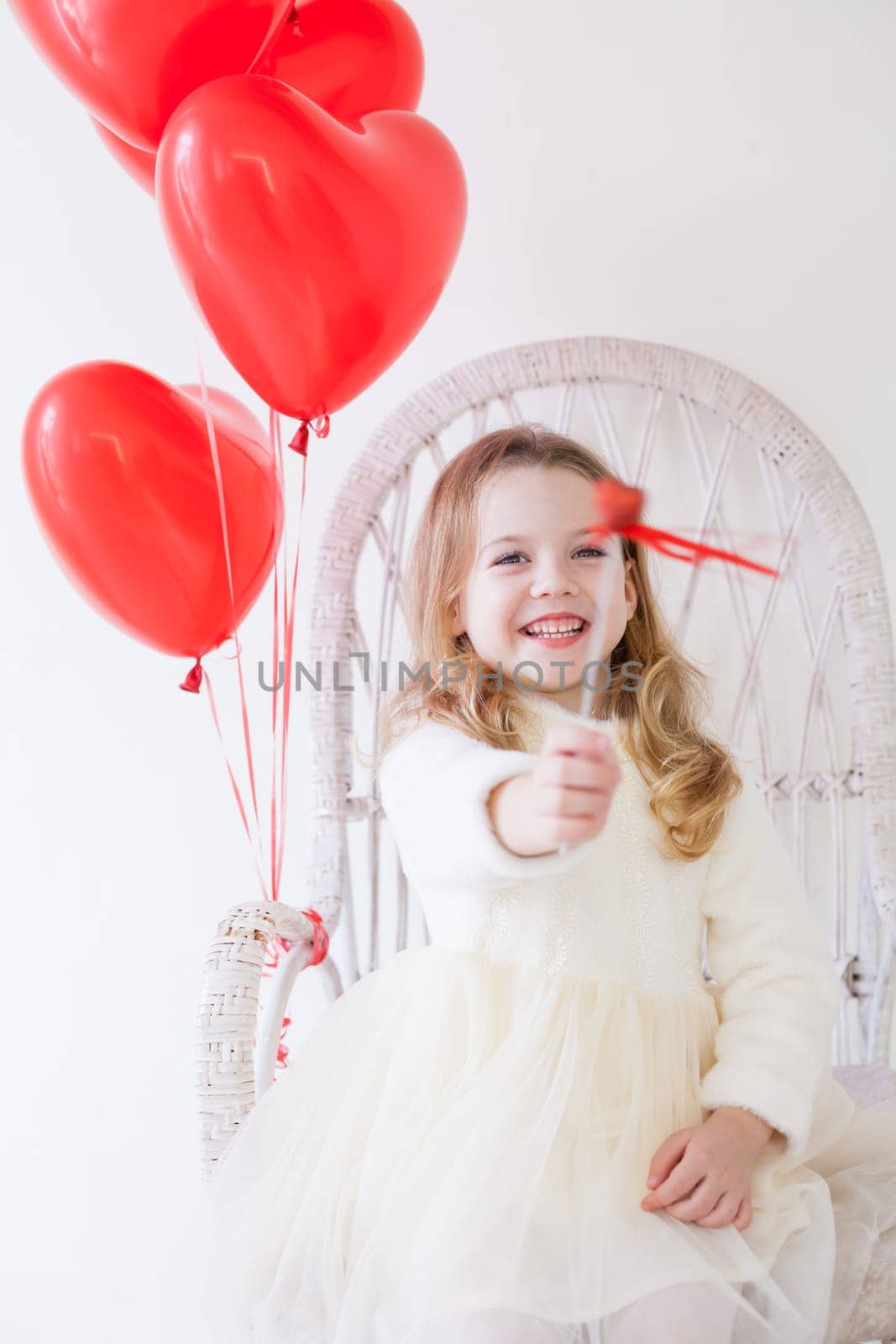 Little girl with red balloons for the holiday