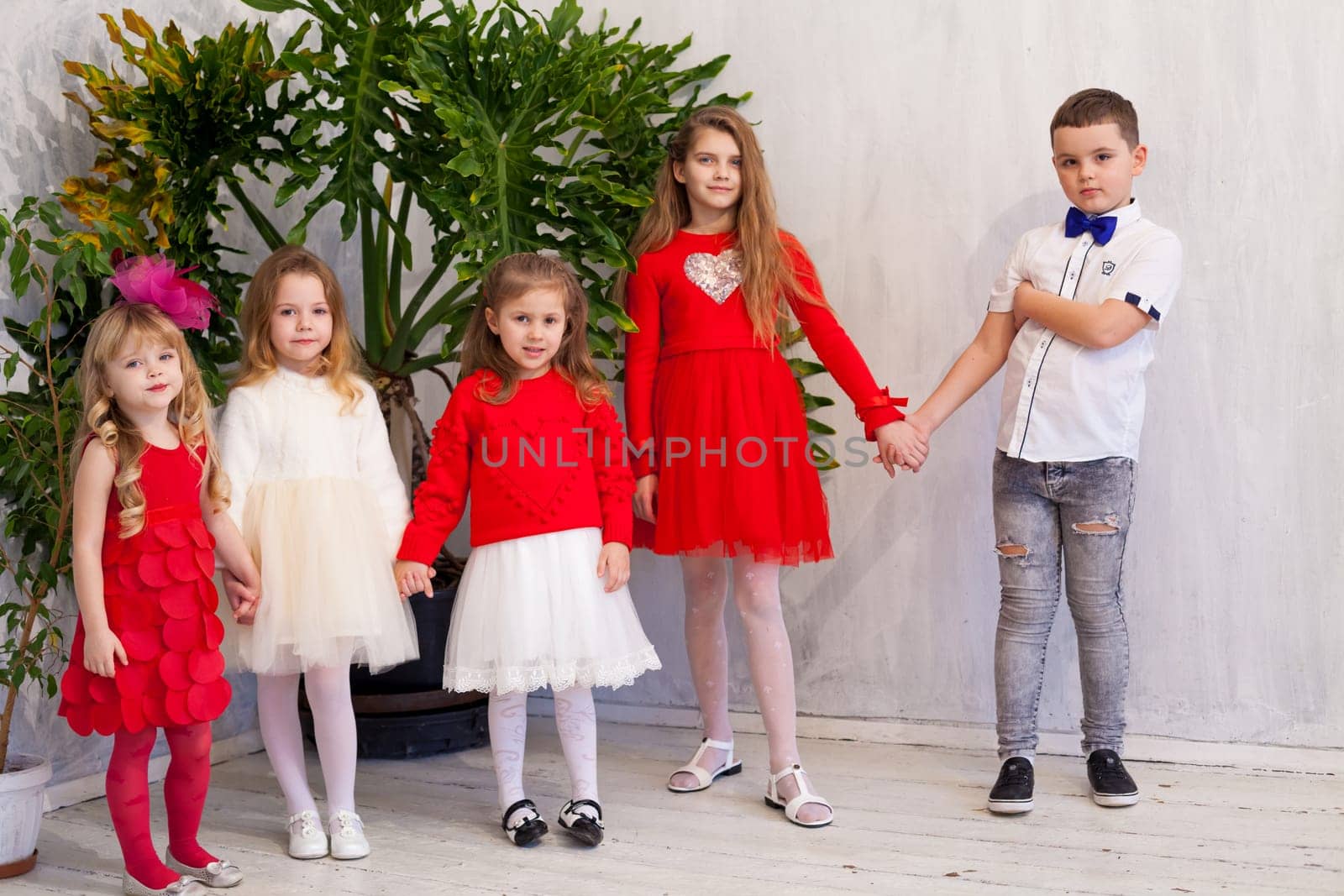 kids are friends of different ages together in a white room by Simakov