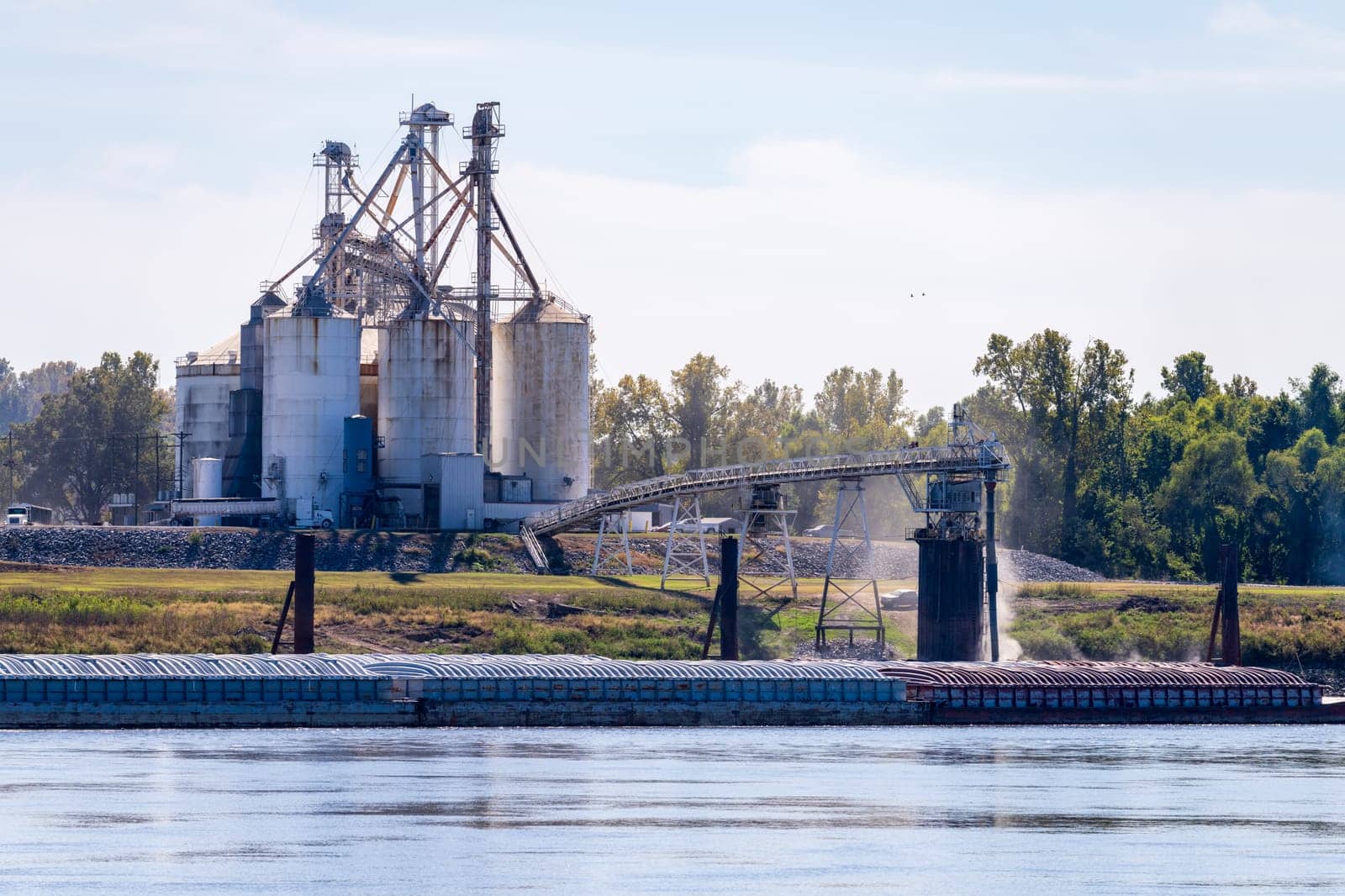 Grain being loaded into freight barges on lower Mississippi river by steheap