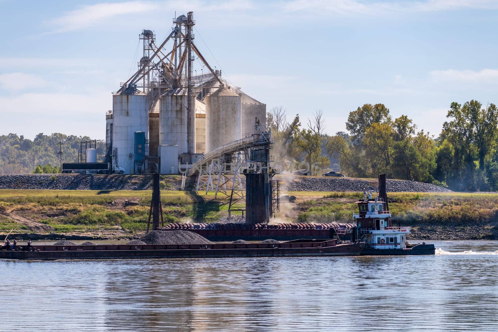 Grain being loaded into freight barges on lower Mississippi river by steheap