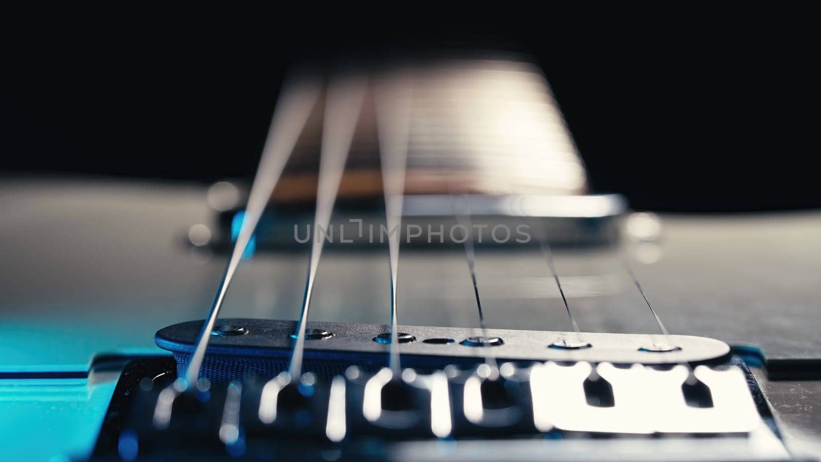 Macro of strings on electric guitar fretboard. Details of instrument close-up. Music, sound, art background. High quality