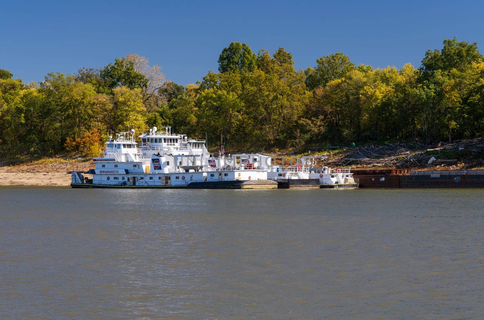 Cairo, IL - 22 October 2023: Three large tugboats or pusher boats docked by river bank of Mississippi river alongside barges