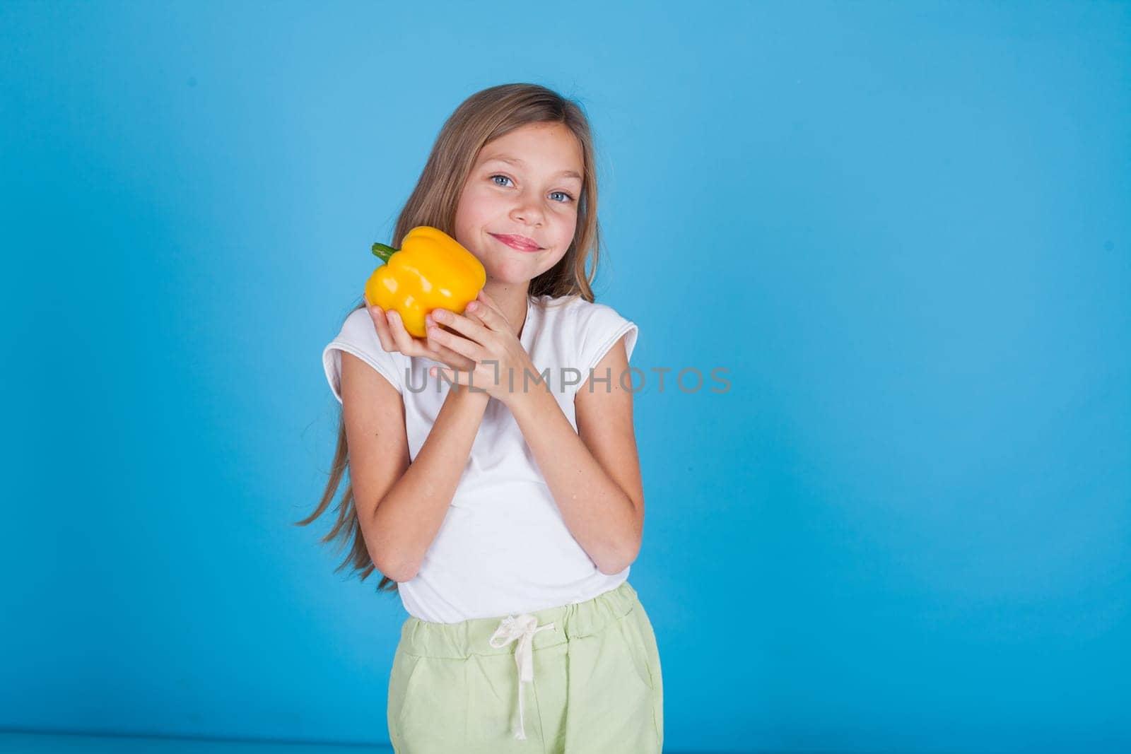 Little girl holds a bell pepper food by Simakov