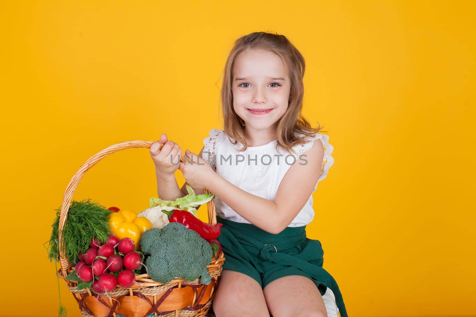 Little girl holds a basket of ripe vegetables by Simakov