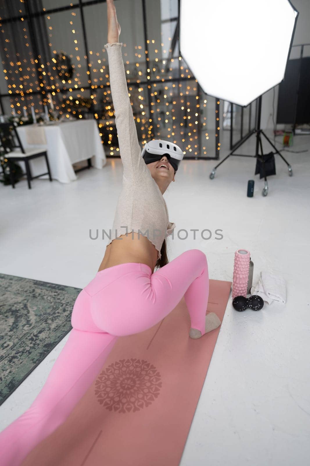 Engaged in sports activities with a virtual reality headset, dressed in stylish pink sportswear by a Christmas tree. by teksomolika