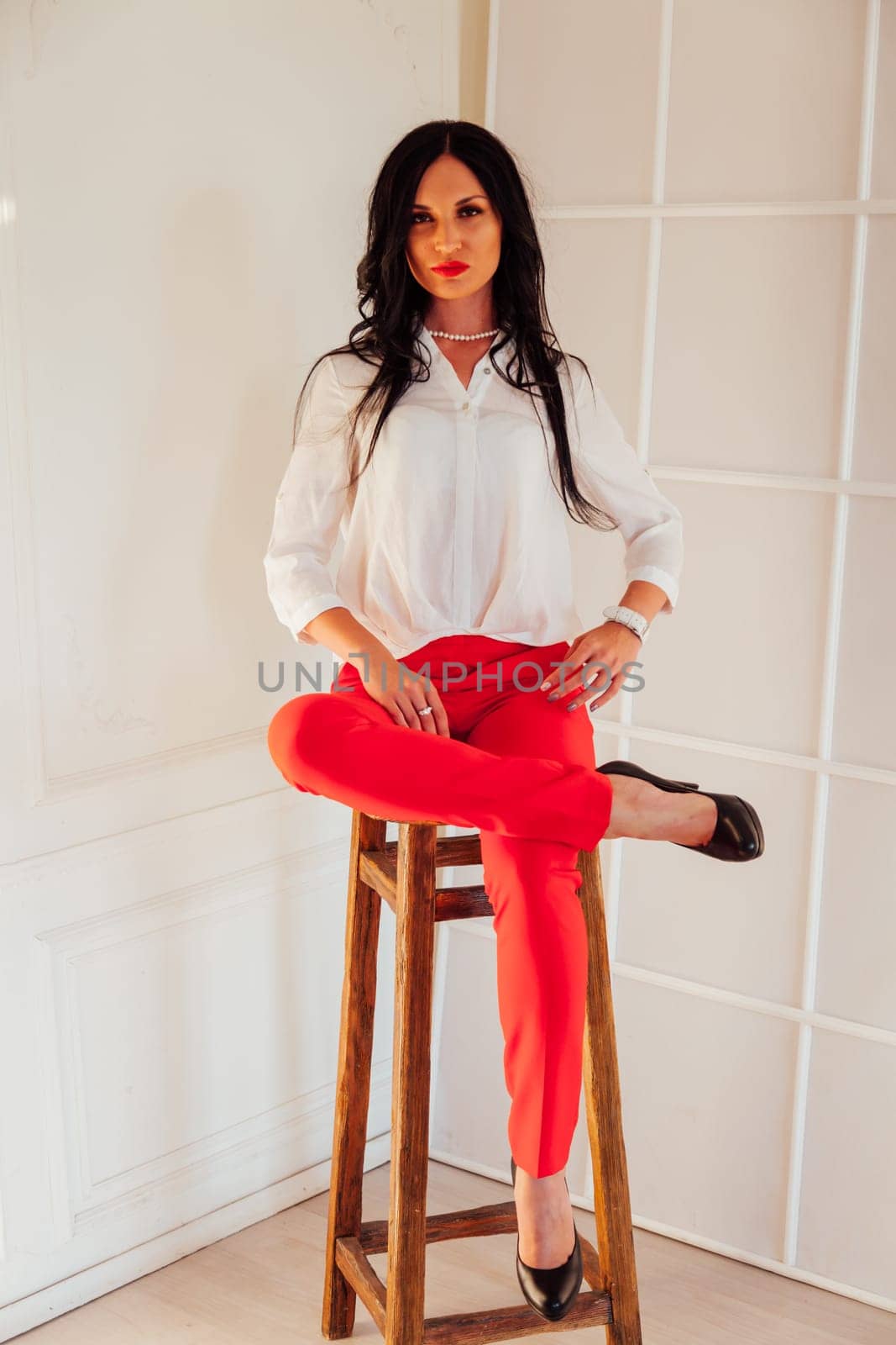 Portrait of a business woman brunette in a red business suit in the office by Simakov