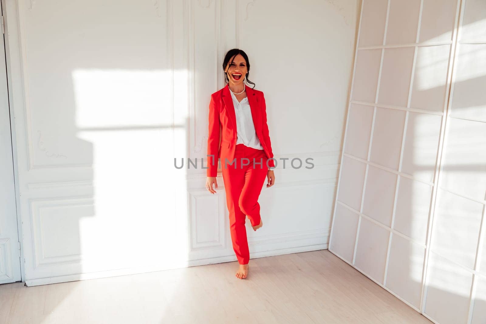 business woman brunette in a red business suit in the office