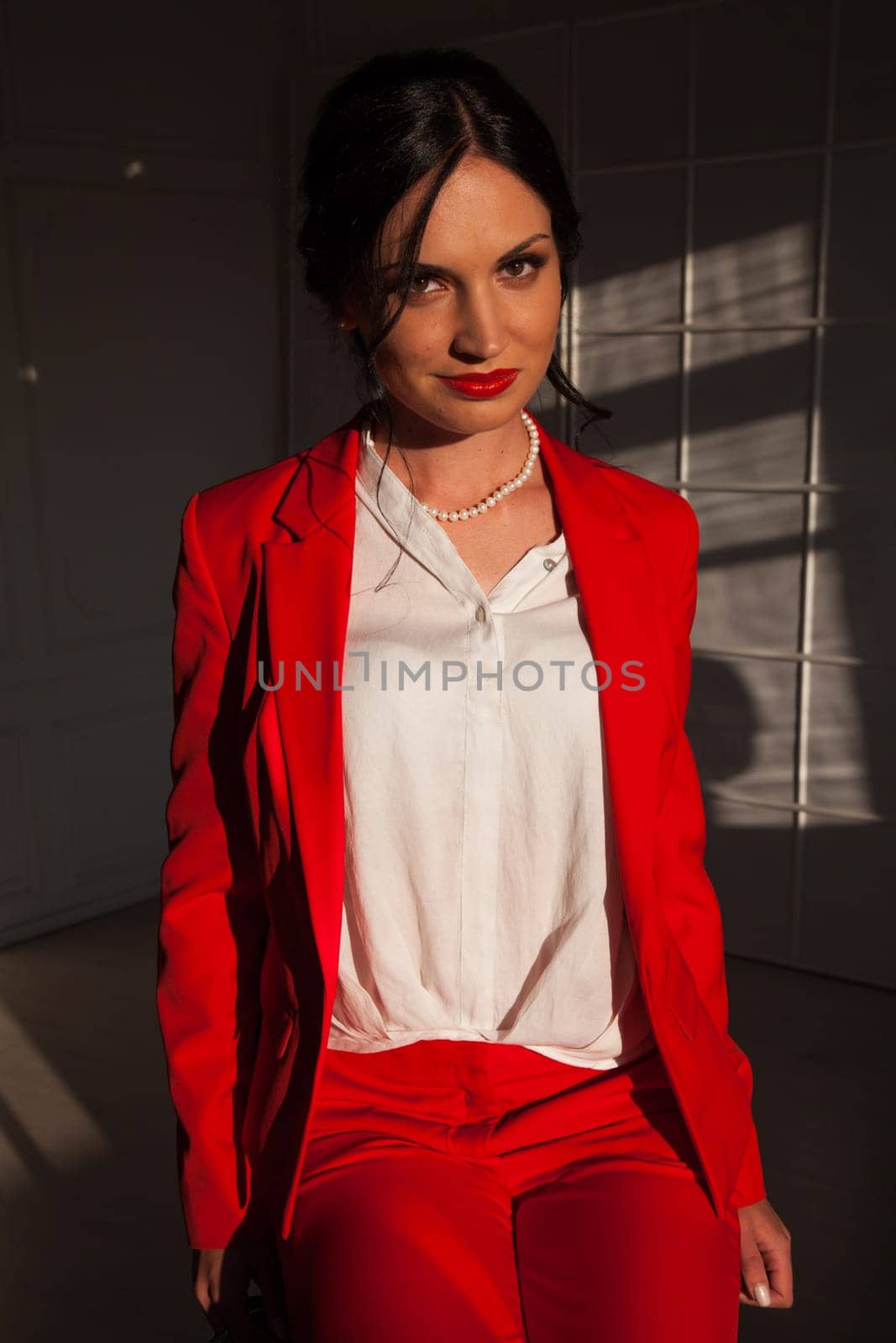 business woman brunette in a red business suit in the office