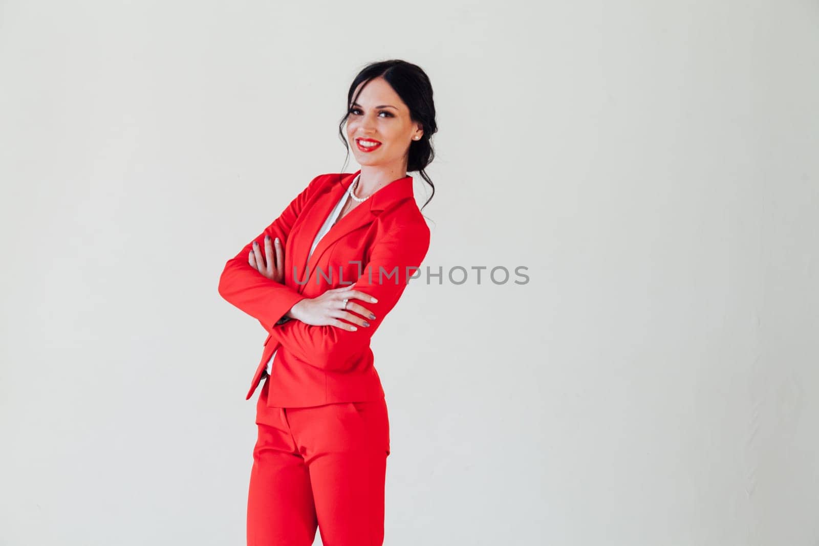 Portrait of a business woman brunette in a red business suit in the office by Simakov