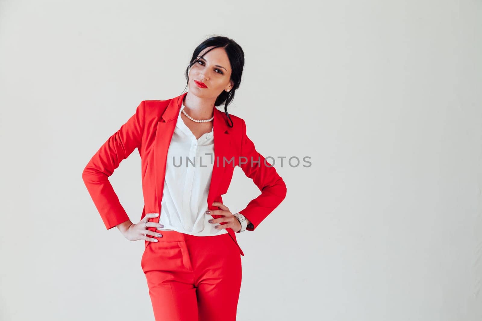Portrait of a business woman brunette in a red business suit in the office by Simakov