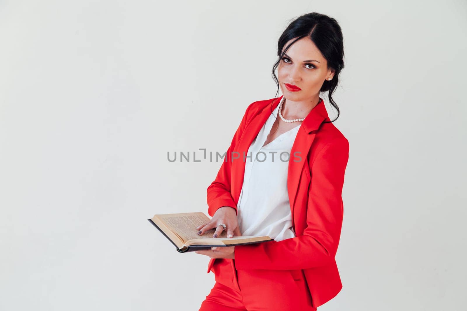 business woman brunette in a red business suit with a book
