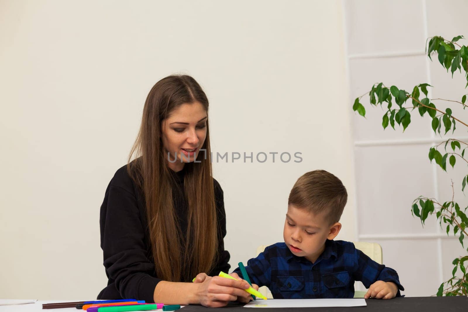 Woman teacher teaches little boy to draw by Simakov