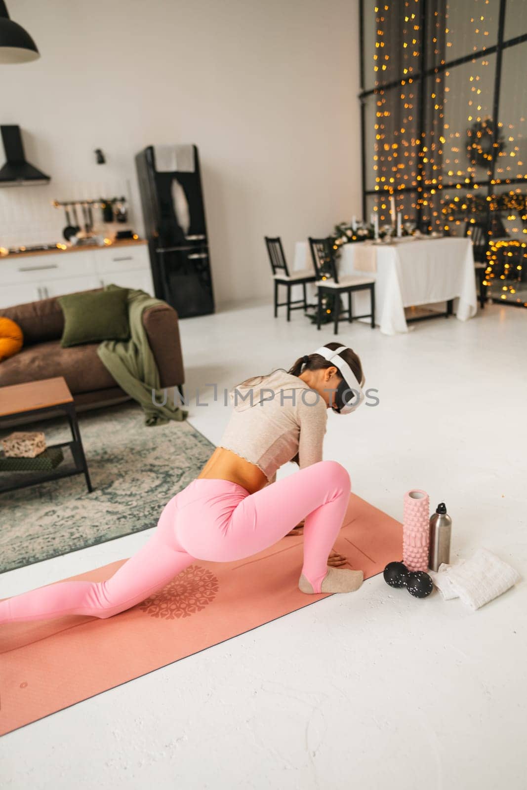Stretching the arms as part of home fitness routines with a virtual reality headset during the festive Christmas season. by teksomolika
