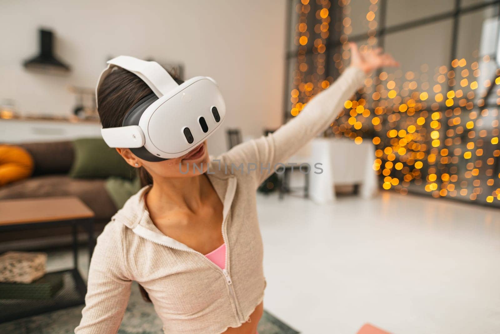 Using a virtual reality headset, a fitness trainer conducts online workout sessions at home during the Christmas holiday season. by teksomolika