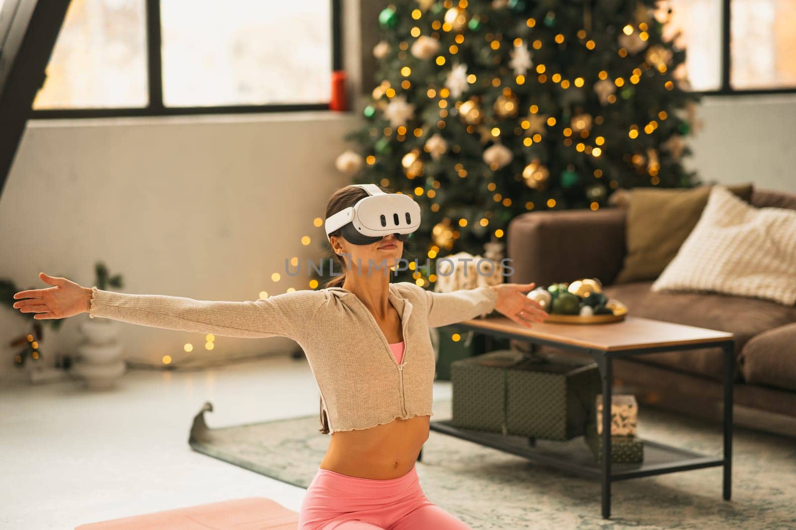 A stylish young woman in workout gear doing stretching exercises in virtual reality. High quality photo