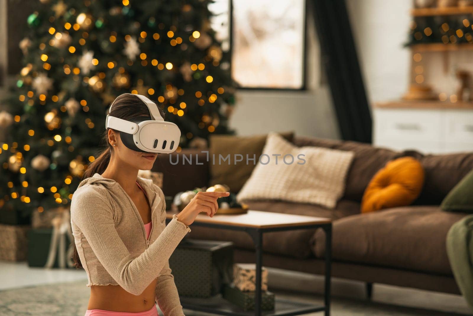 An attractive, athletic woman using a virtual reality headset while stretching. High quality photo
