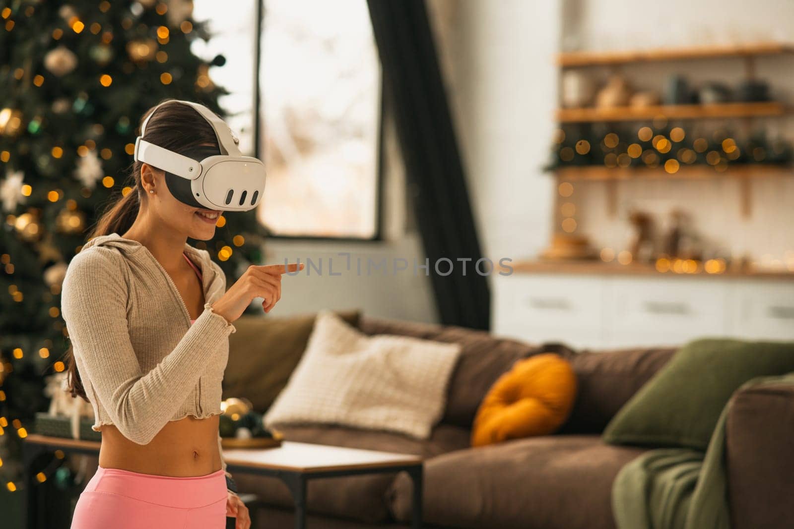 A fit and beautiful woman doing her stretches in virtual reality with a headset on. by teksomolika