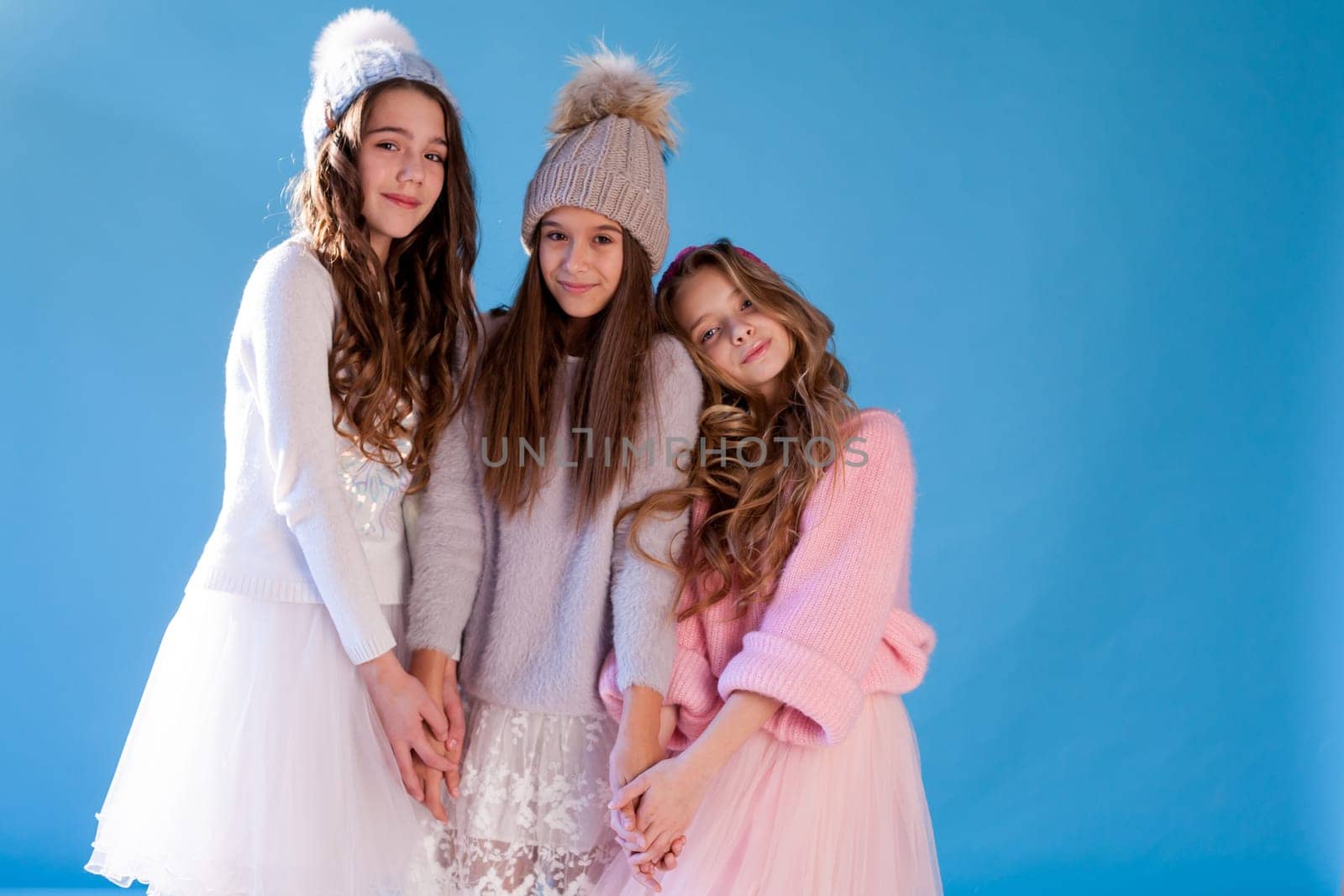 Three girls school girlfriends in winter snow cold hats by Simakov