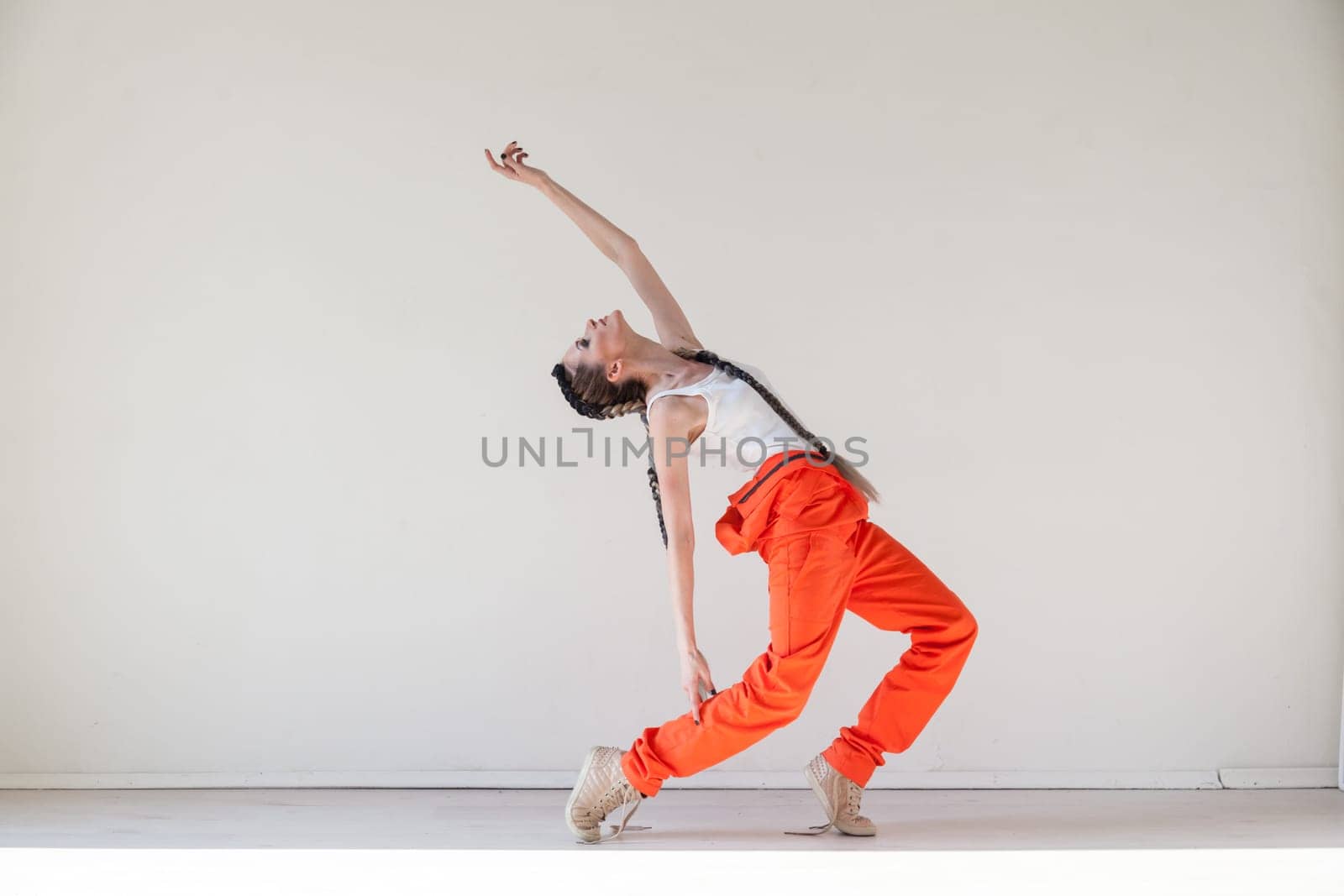 Woman with braids dances to music orange by Simakov