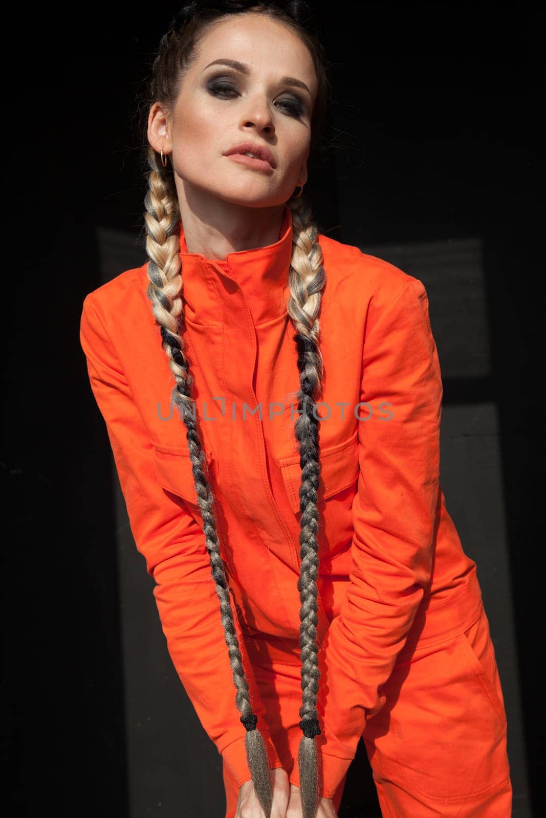 portrait of a beautiful woman with braids in orange work clothes
