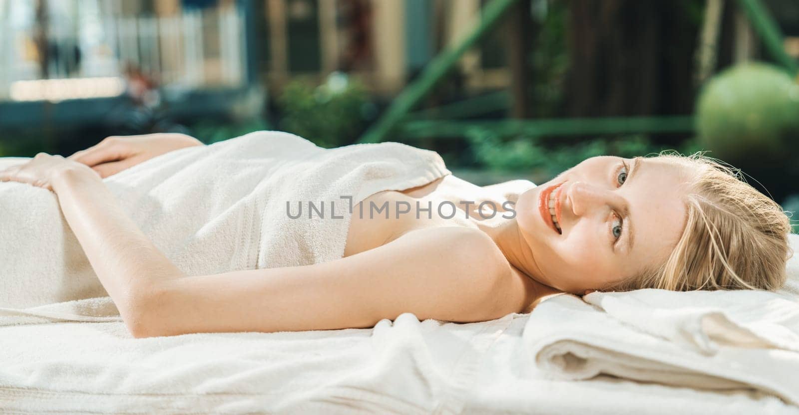 Beautiful young woman relaxes on a spa bed surrounded by nature. Tranquility by biancoblue