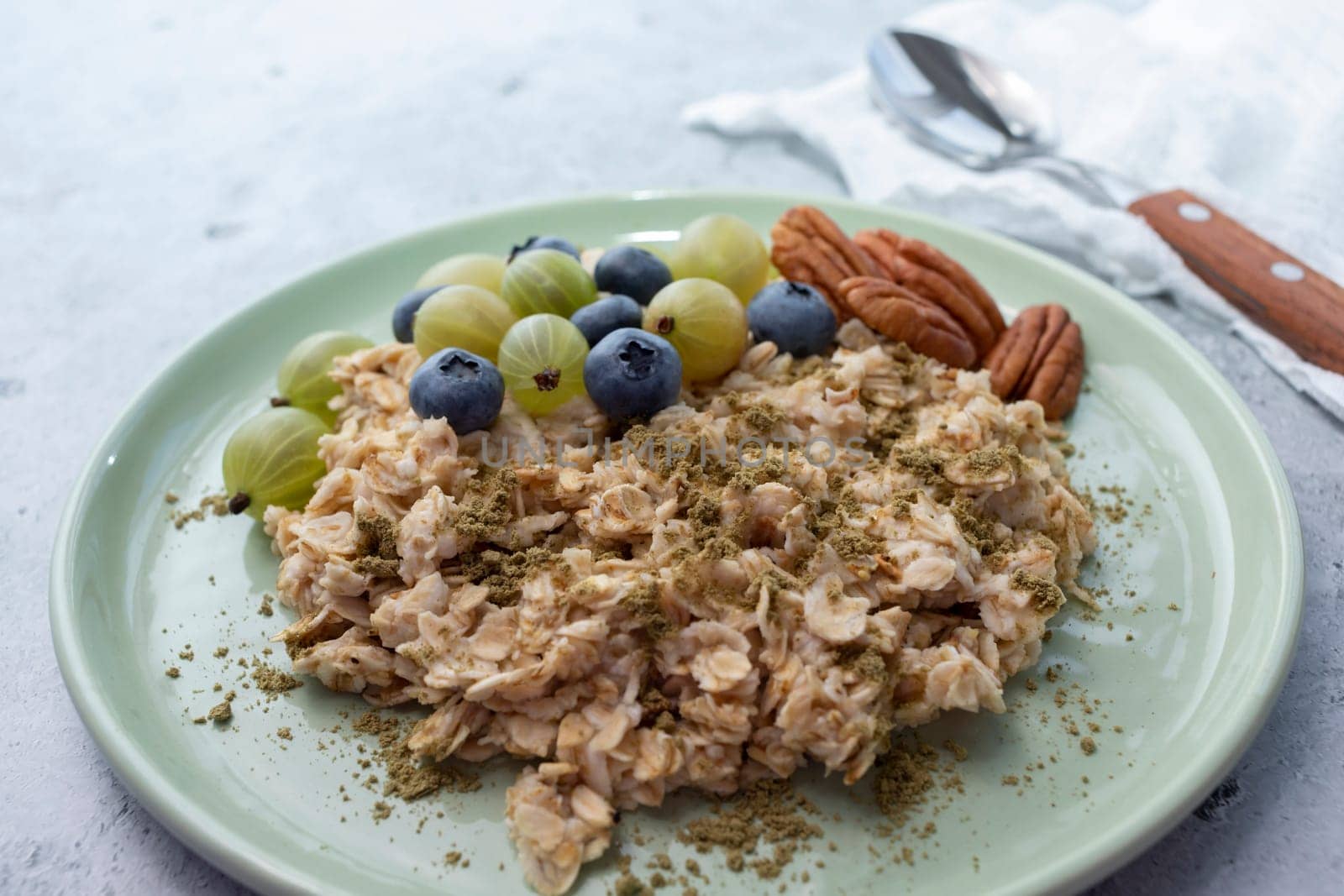 Closeup Oatmeal Porridge With Hemp Protein Powder, Berries, Nuts On Plate. Body hacking, Biohacking Healthy Breakfast With Plant-derived Protein from Cannabis Plant. Superfood, Healthy Meal Horizontal