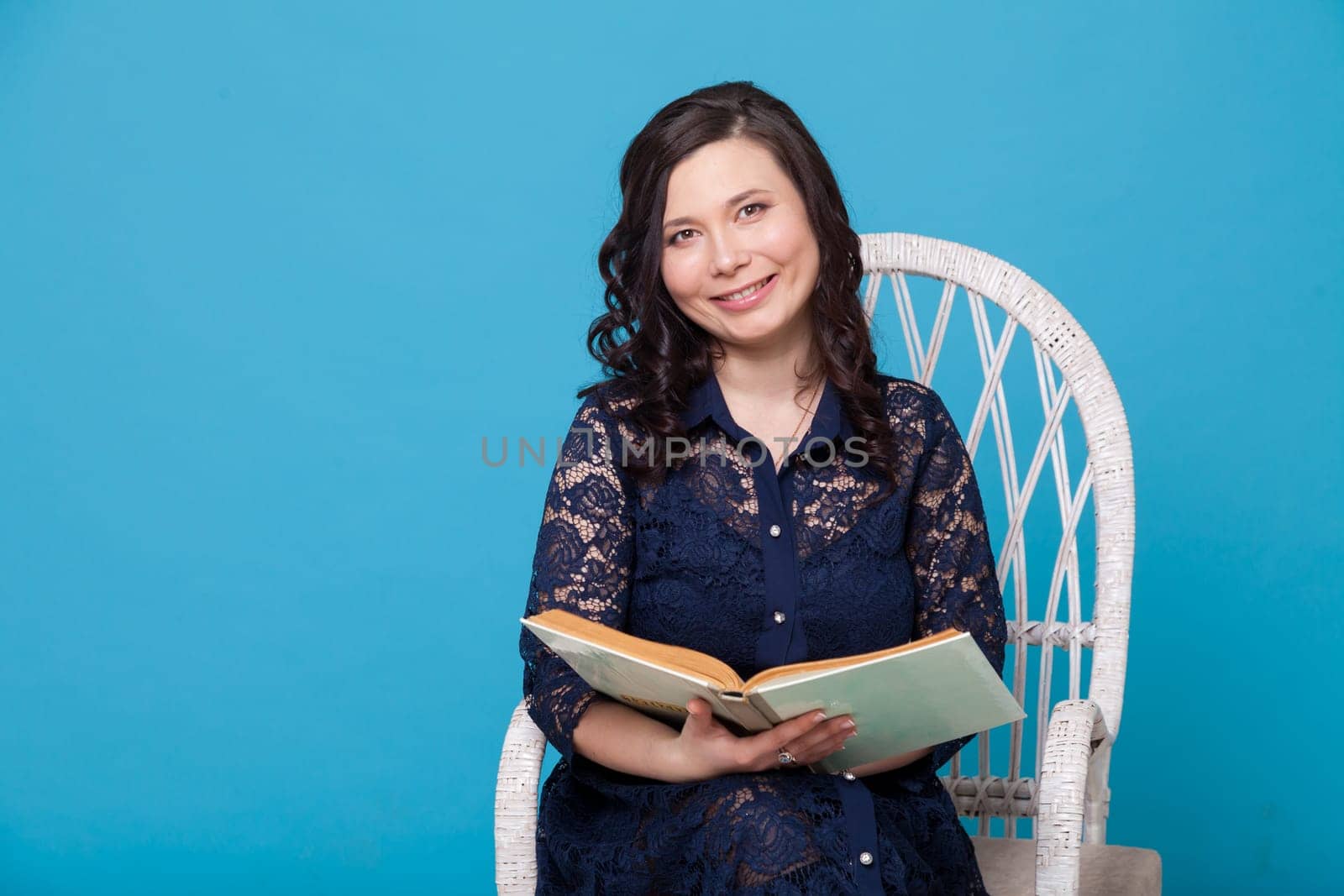 Portrait of a beautiful Asian woman reads a white book by Simakov