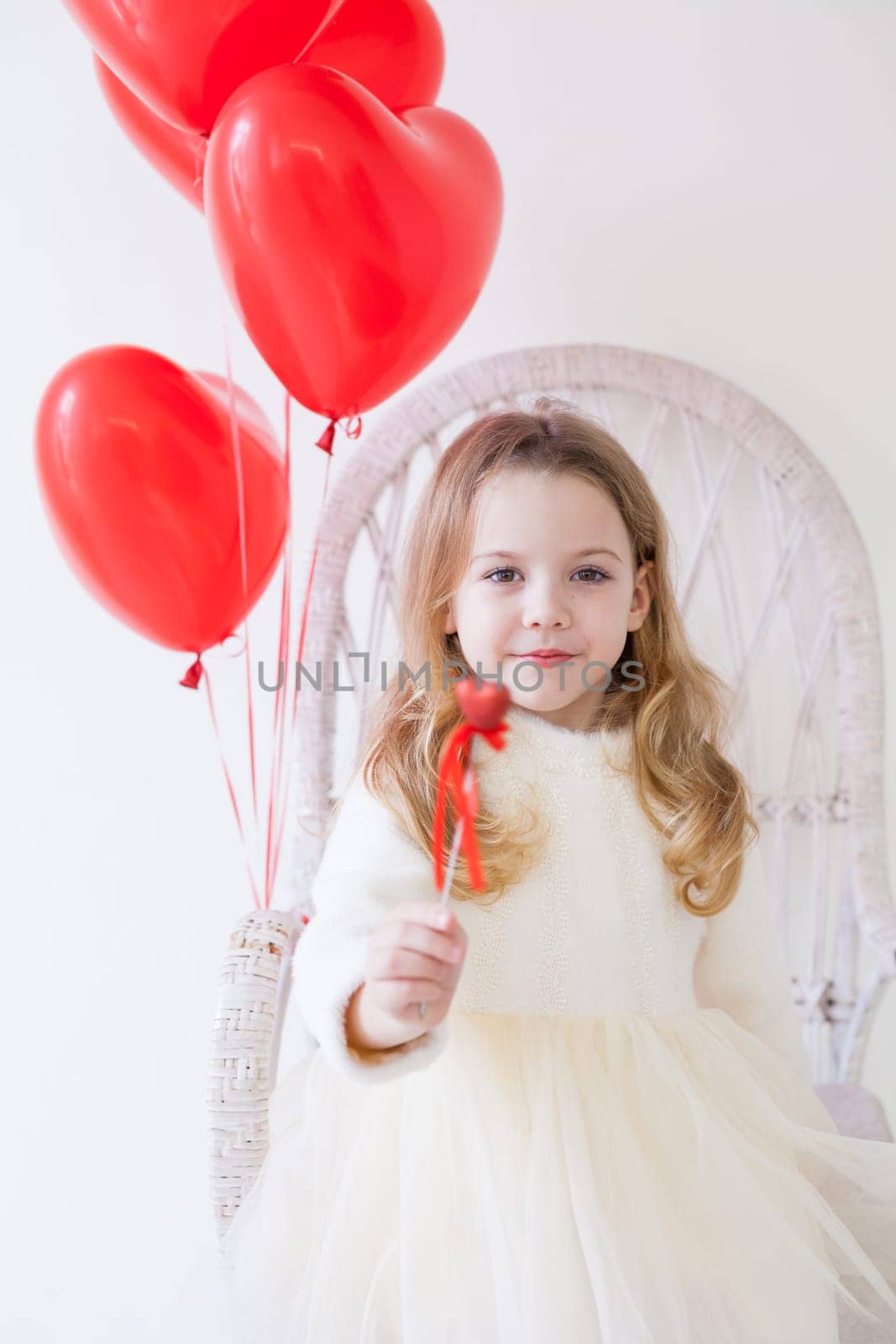 Little girl with red balloons on Valentine's Day by Simakov