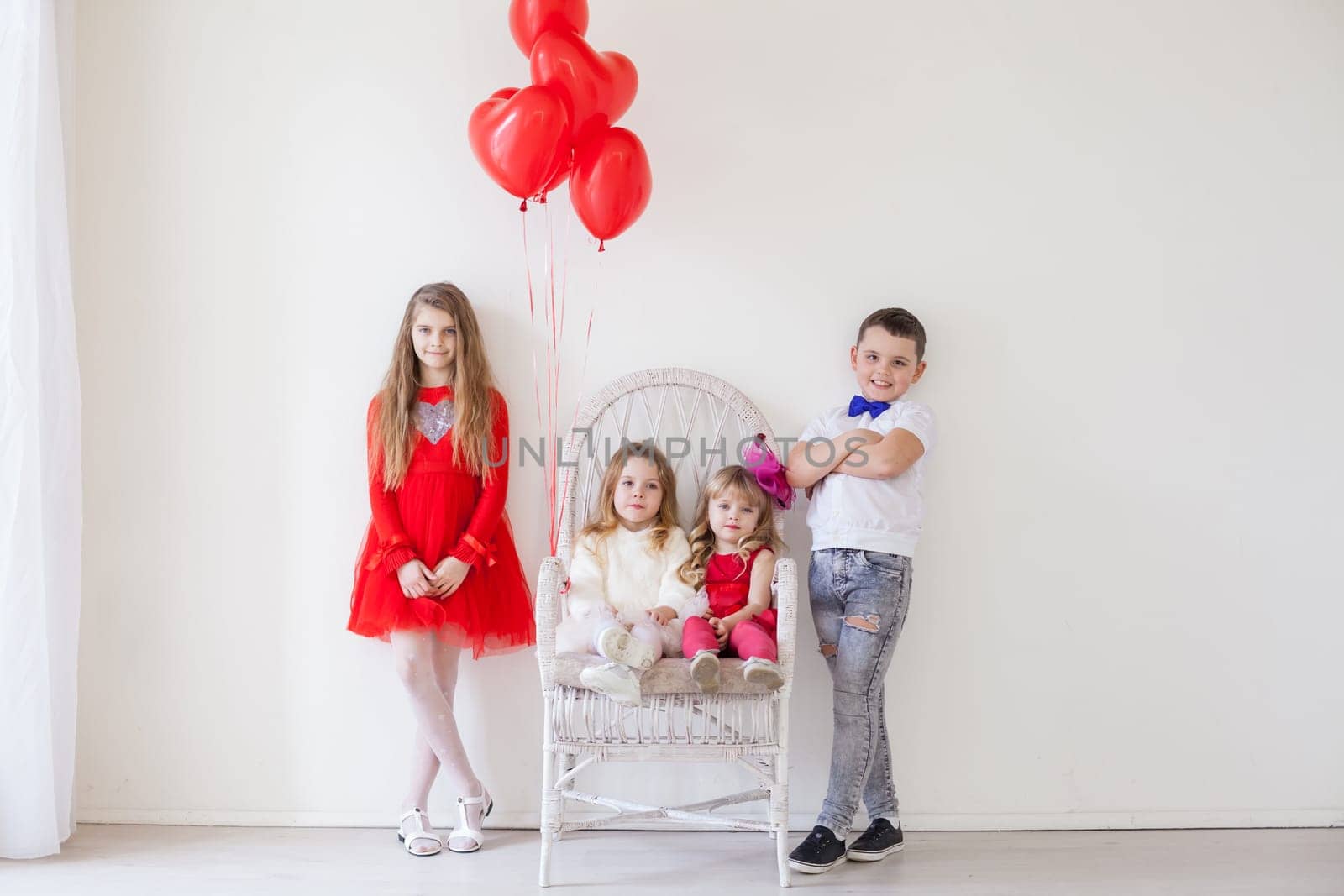 three girls and a boy with balloons on Valentine's Day by Simakov