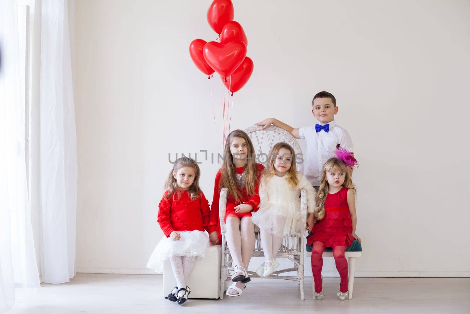 three girls and a boy in red and white clothes with balloons Feb.