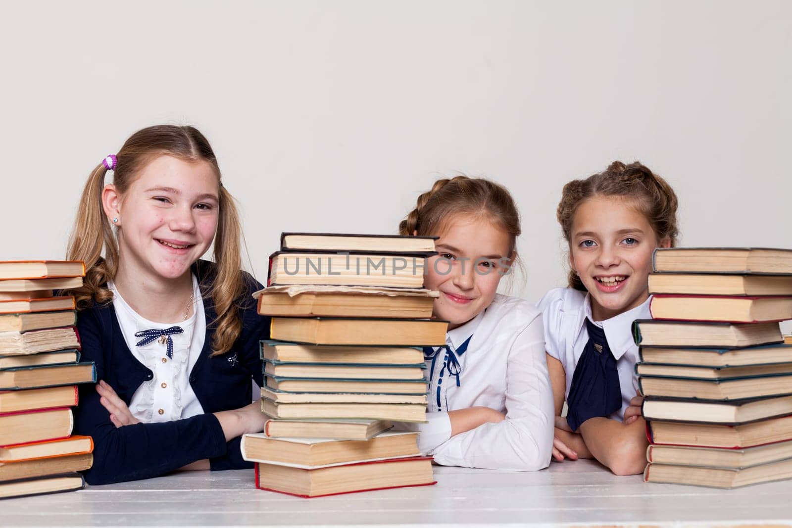 two girls with books in class at a desk at school