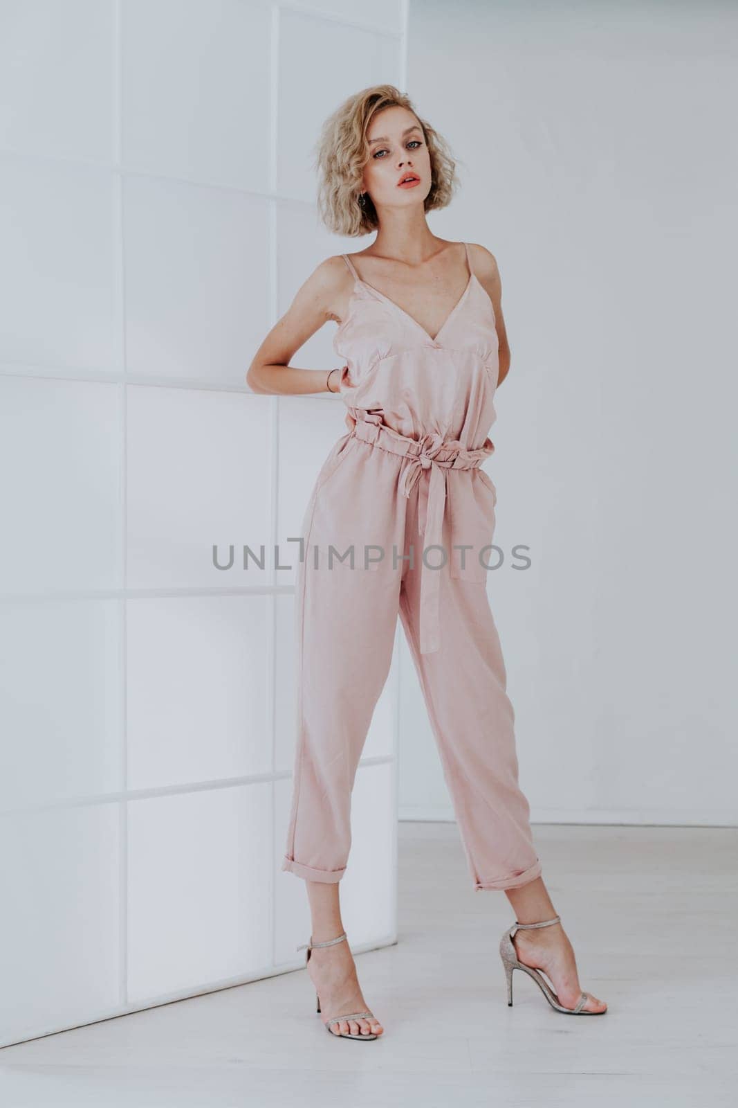 Portrait of a beautiful fashionable woman in a pink jumpsuit by Simakov