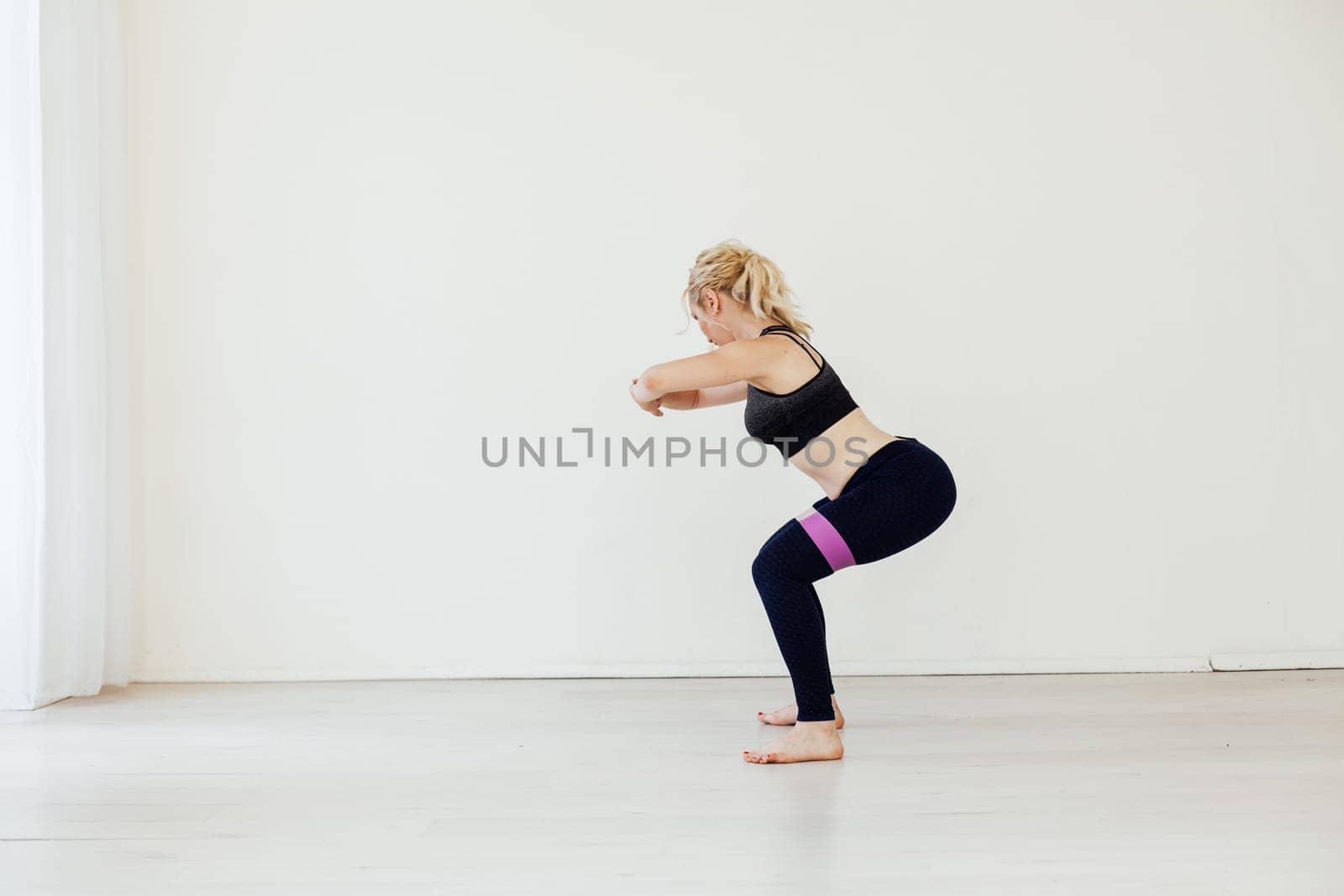 Blonde woman sports in gym with fitness gum