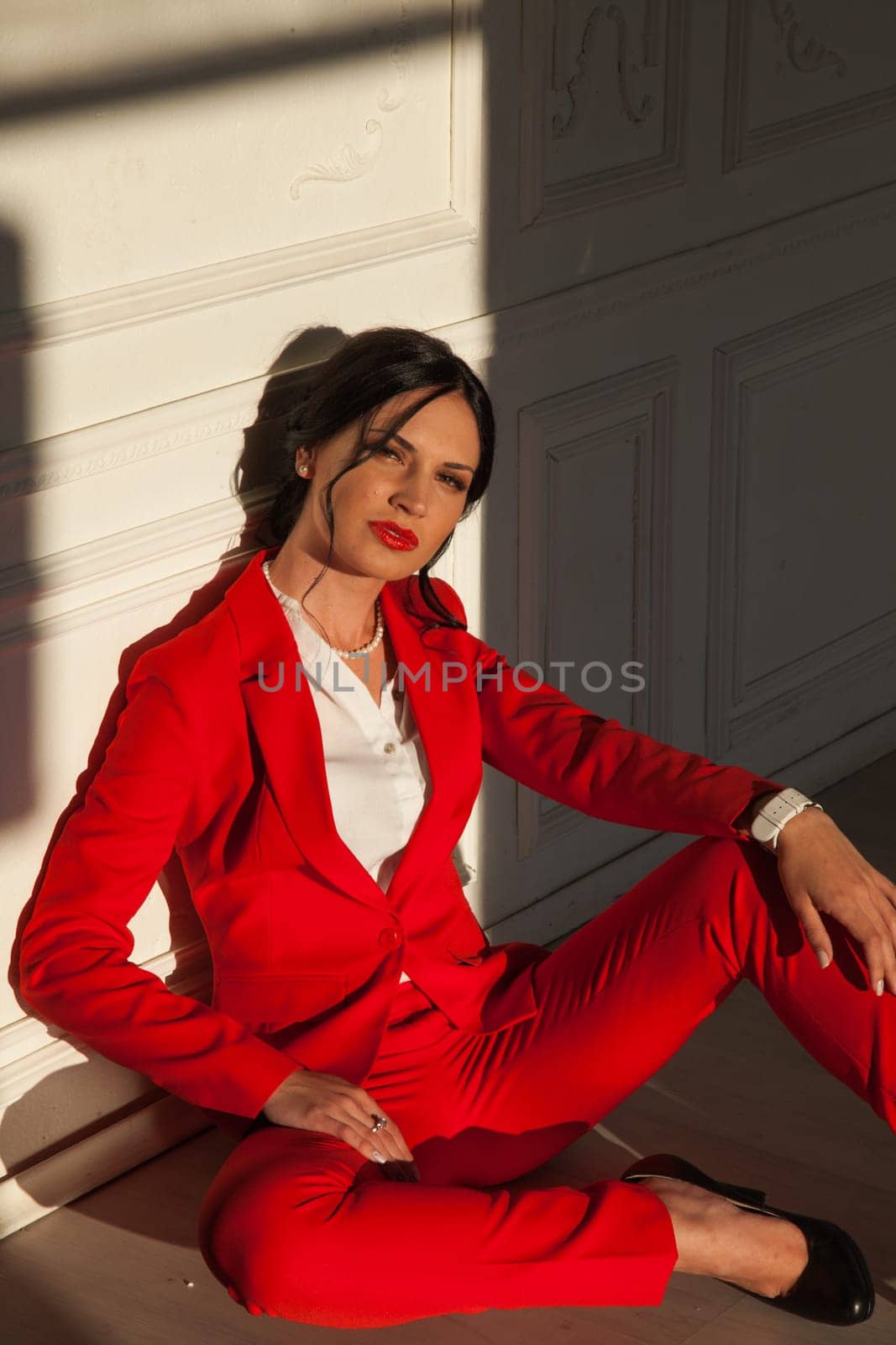 portrait of a beautiful woman in a red business suit in the office by Simakov