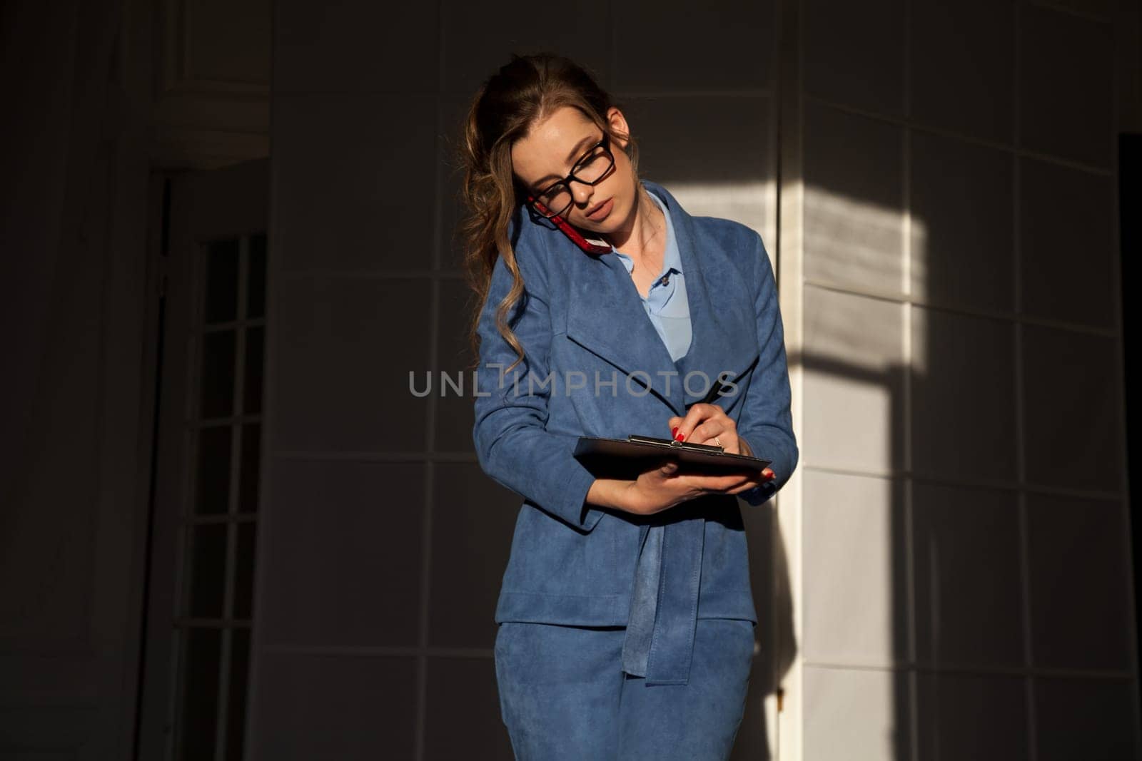 portrait of a beautiful woman in a business suit in the office at work by Simakov