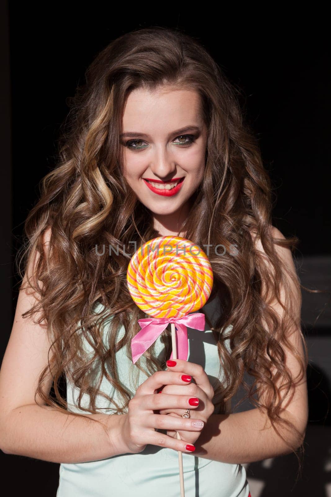 Beautiful woman eats a big candy sweet lollipop by Simakov