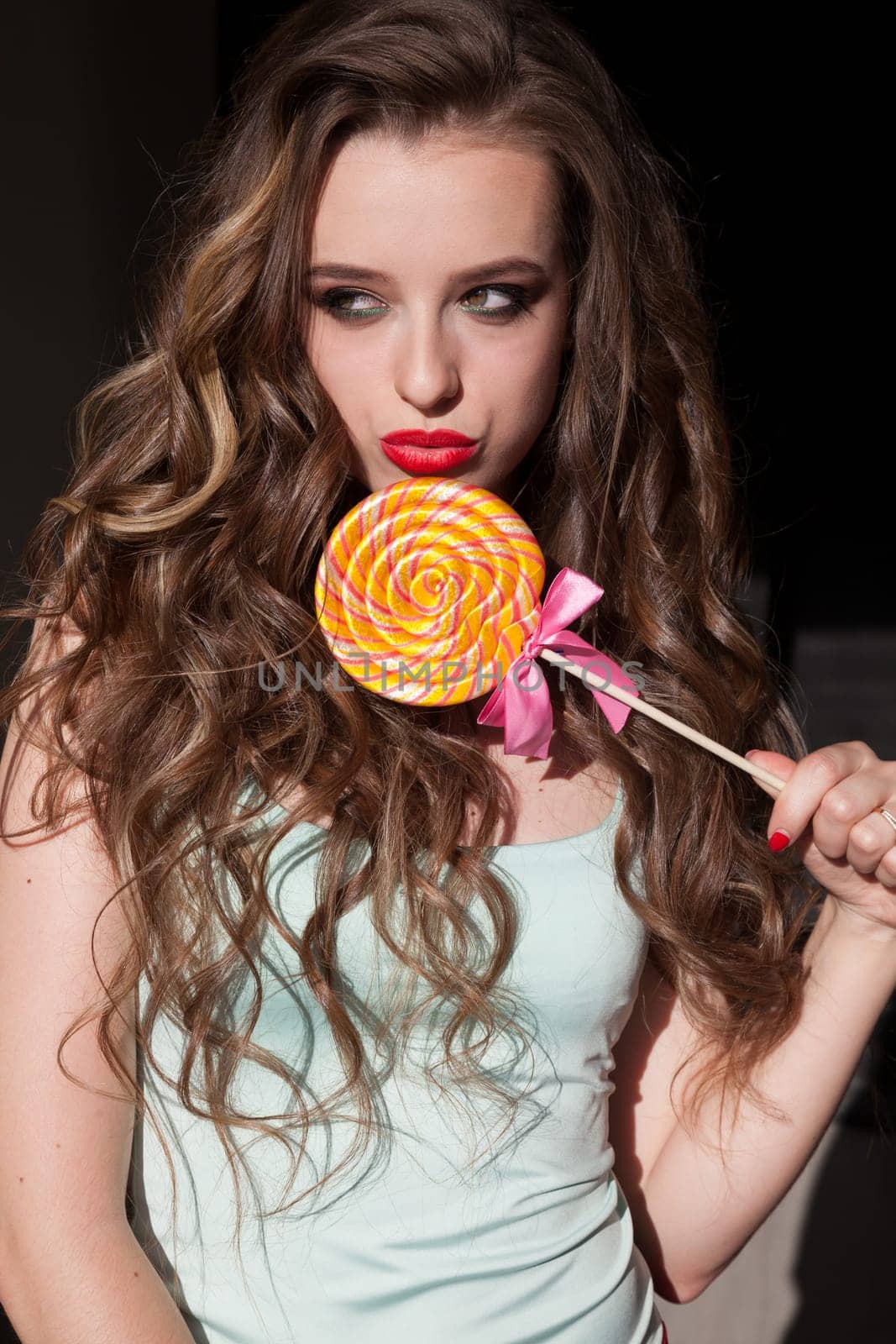 Beautiful woman eats a big candy sweet lollipop by Simakov